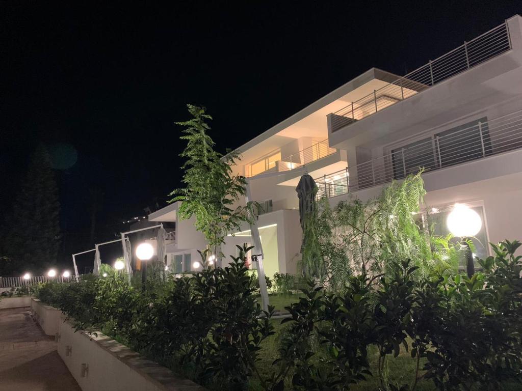 un edificio bianco con luci di notte davanti di Residence Chanel a Santa Maria di Castellabate