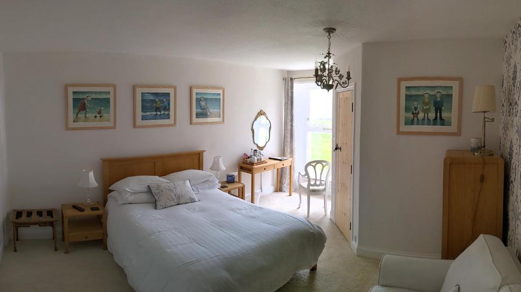 a bedroom with a large white bed and a chair at The Burrows Bed and Breakfast in Pembroke