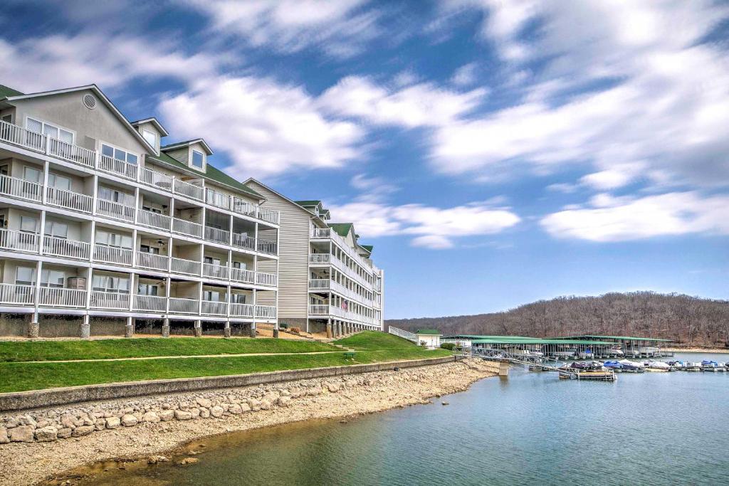 a large apartment building next to a body of water at Osage Beach Condo with Private Boat Slip, Views in Osage Beach