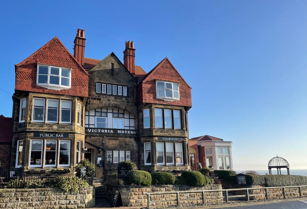 an old house with the ocean in the background at Victoria Hotel in Whitby