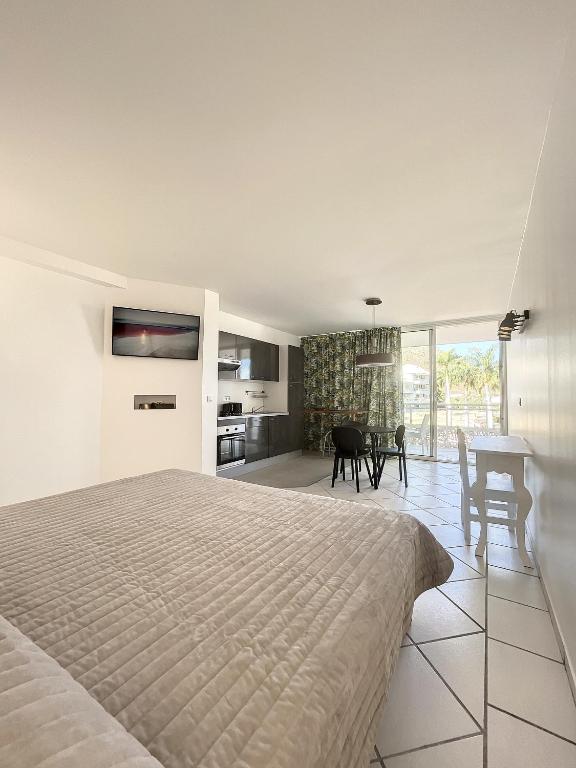 a bedroom with a bed and a table and chairs at Le Domaine Anse Marcel Beach Resort in Anse Marcel 
