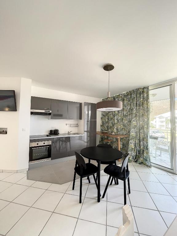 a kitchen with a black table and black chairs at Le Domaine Anse Marcel Beach Resort in Anse Marcel 