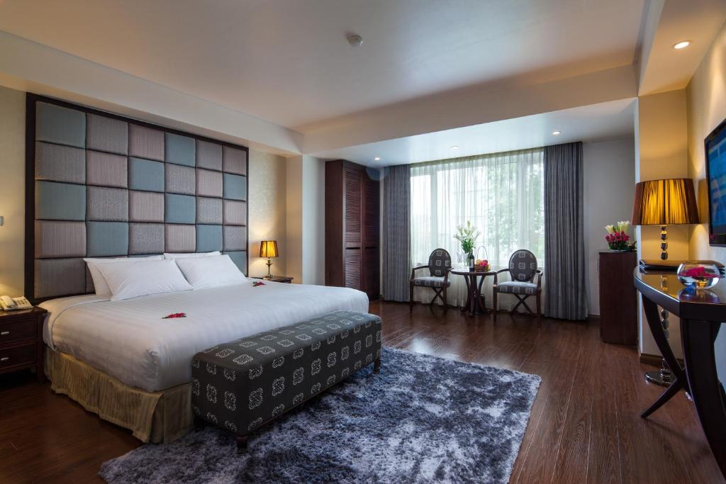 a bedroom with a large bed and a large window at Dragon Pearl Hotel in Hanoi