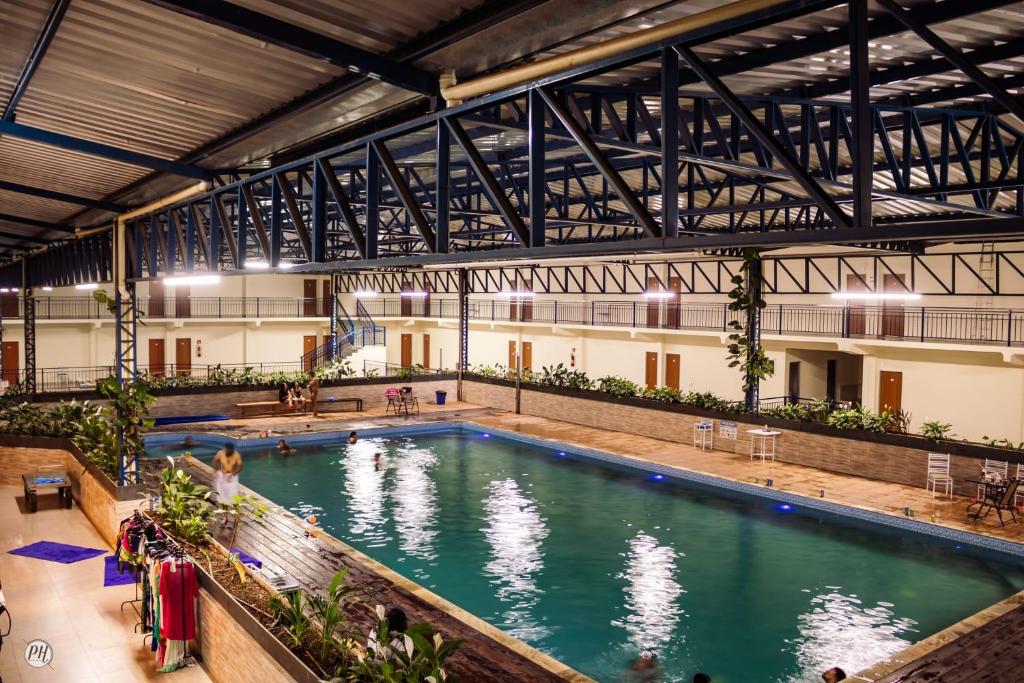 a large indoor swimming pool with people in it at Hotel farol de Minas in Alpinópolis