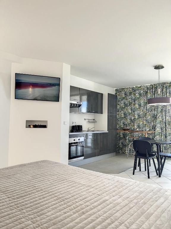 a bedroom with a bed and a table and a kitchen at Le Domaine Anse Marcel Beach Resort in Anse Marcel 
