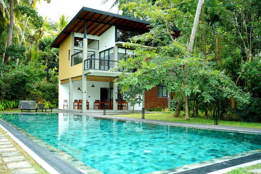 een huis met een zwembad voor een huis bij Sakuna Arana Resort in Kosgoda
