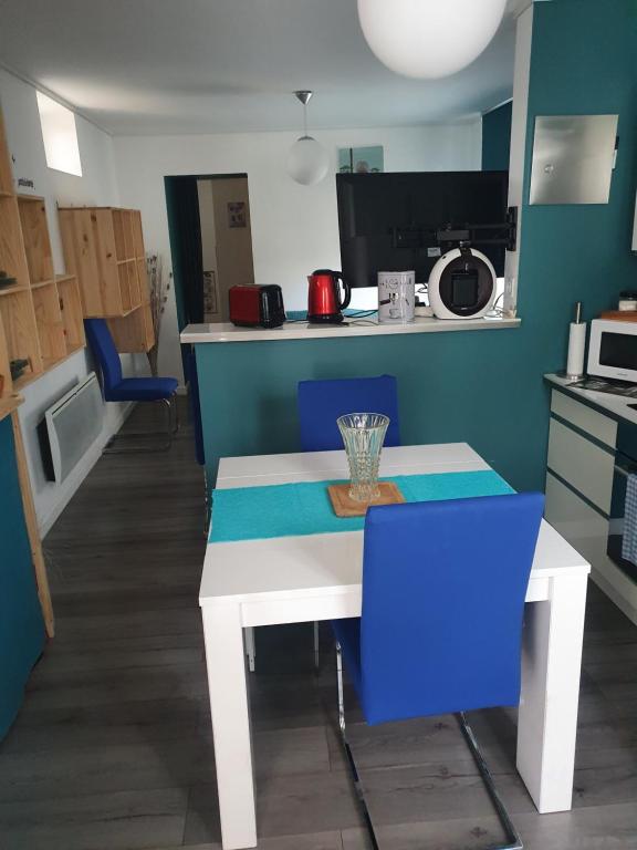 奧伯納的住宿－La maison de Nathoune，厨房配有白色的桌子和蓝色的椅子