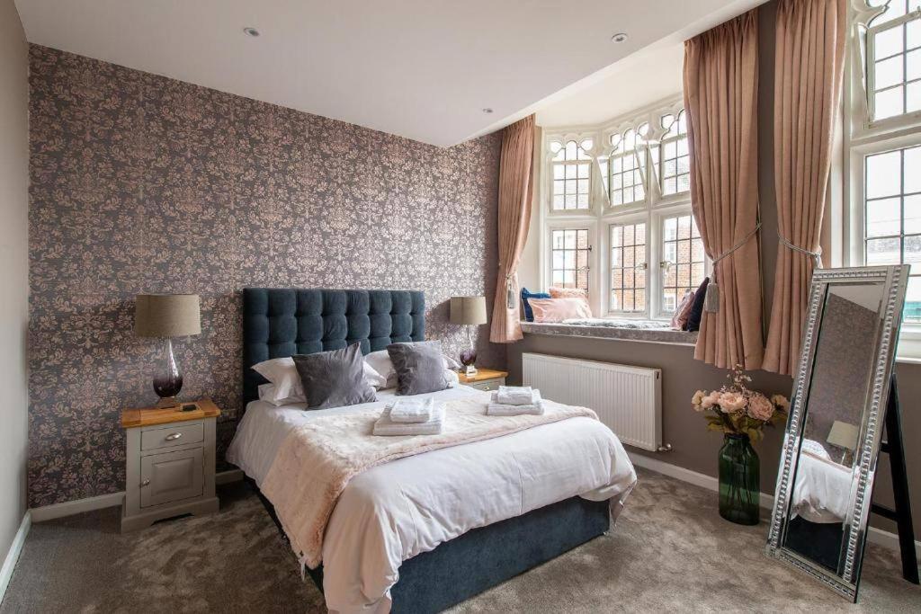 a bedroom with a large bed and a mirror at THE MOST CENTRAL Apartment in Canterbury Stunning Interiors, fully equipped, City Views and Free WiFi! in Kent