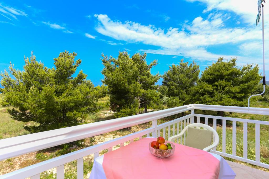 a table with a bowl of fruit on a balcony at Apartment 5, first floor in Rogoznica