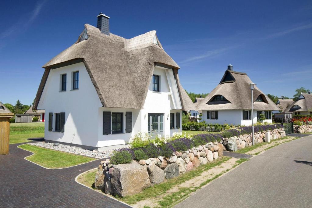 a large white house with a thatched roof at Holiday house, Fuhlendorf in Fuhlendorf