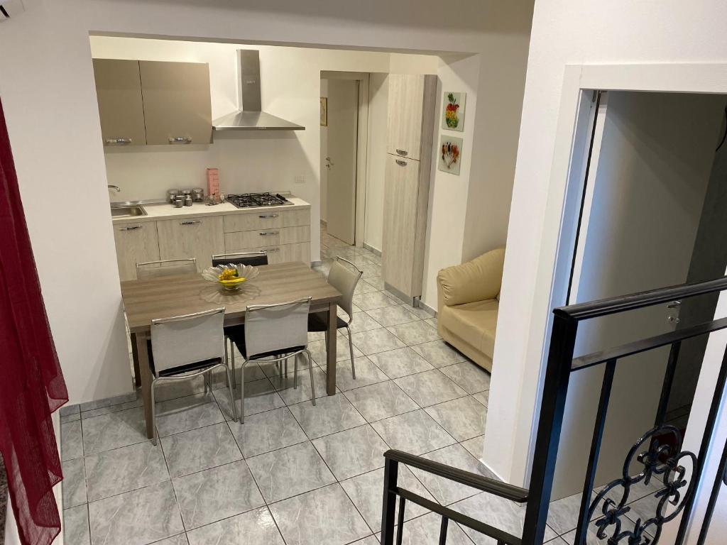 una cucina e una sala da pranzo con tavolo e sedie di AG sweet apartment a Reggio di Calabria