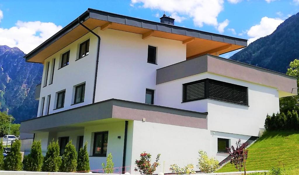 a white building with a roof on a hill at Living Apartment Maurer in Sautens