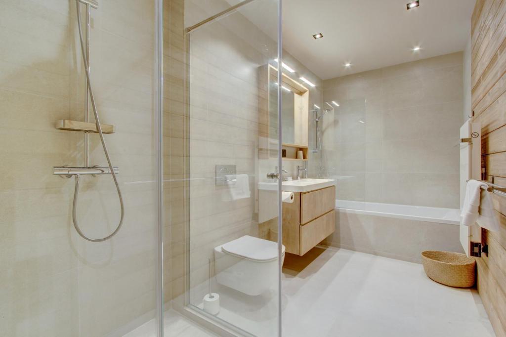 a bathroom with a shower and a toilet and a sink at Chalet La Mésange Boréale in Morzine