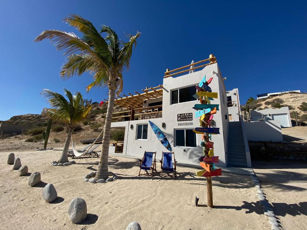 una casa en la playa con un cartel en la arena en Beach Front Lofts, La Ventana, en La Ventana