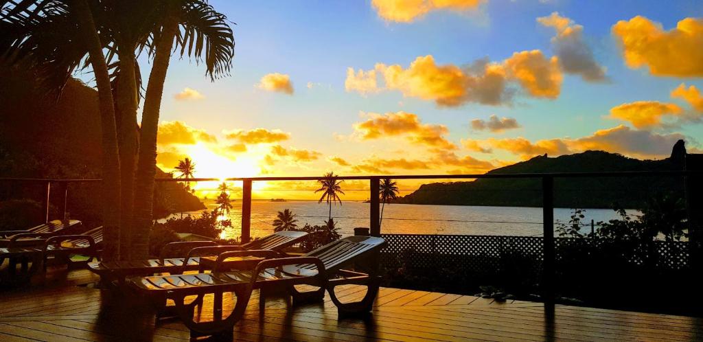 un tramonto su una terrazza con panchine e oceano di Villa Maroe (étage entier, deux chambres, salle de bain et cuisine) a Fare (Huahine Nui)