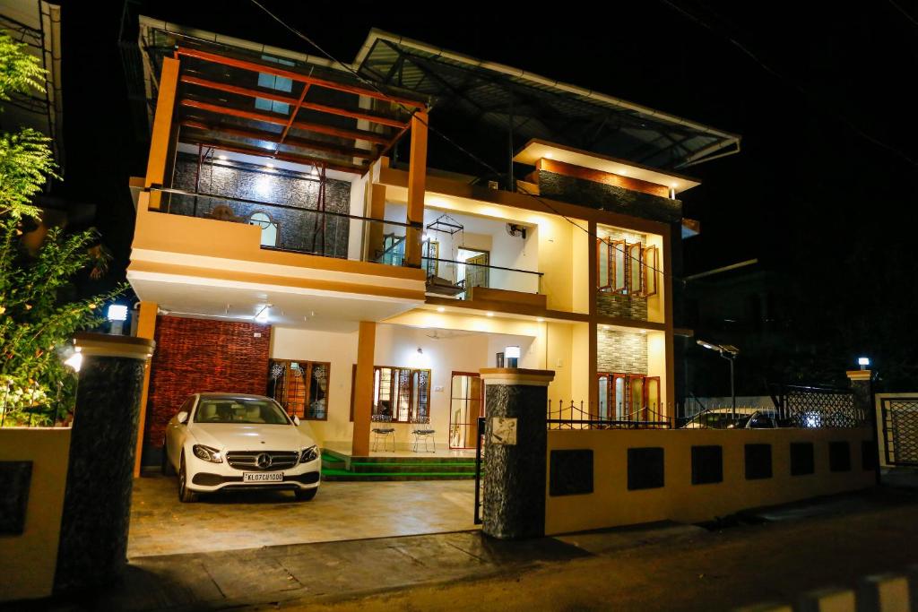 une voiture garée devant une maison la nuit dans l'établissement Belljem Homes -your own private resort -1 BR, à Thrissur