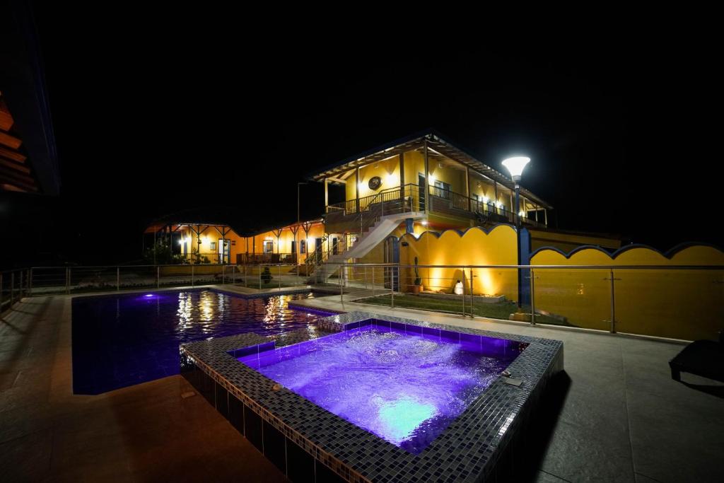 un edificio con piscina por la noche en Ecohotel Guaduales Pereira en Pereira