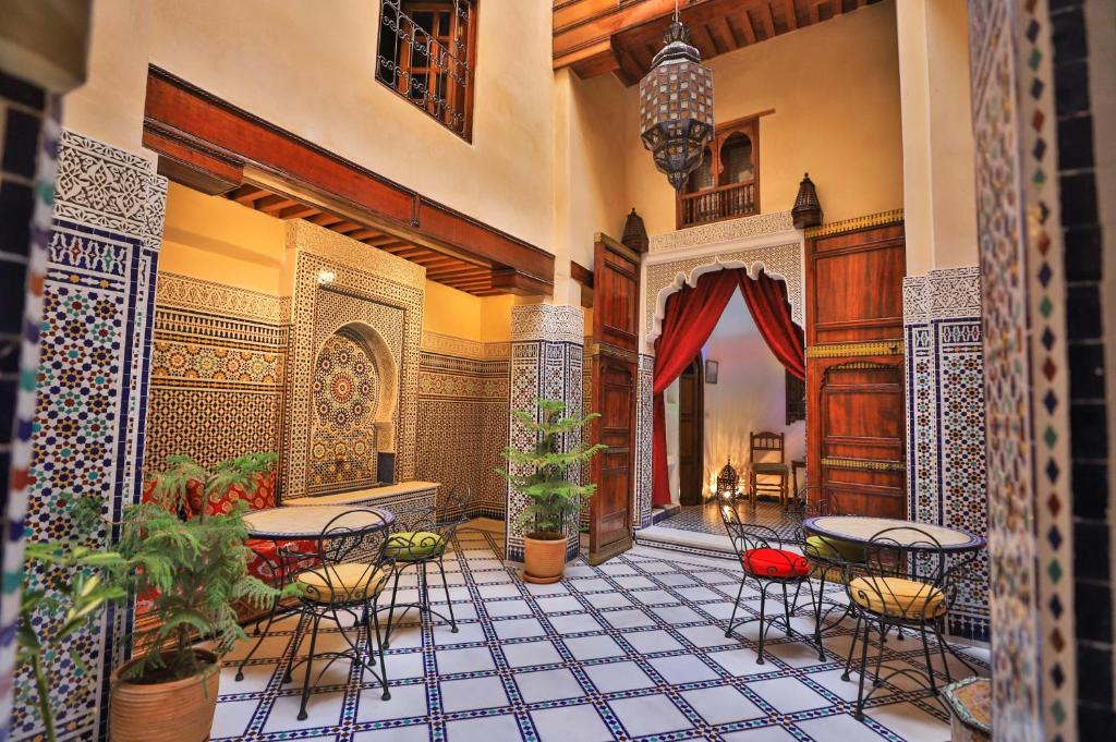 a room with tables and chairs on a tiled floor at Guesthouse Dar Othmane in Fez
