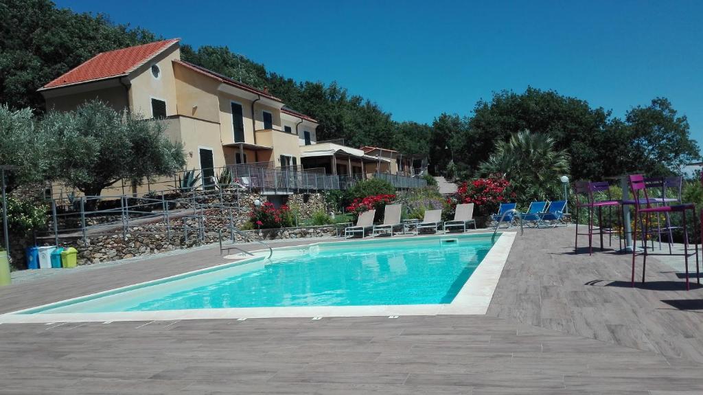 a swimming pool in front of a building with a house at Oroverde in Bergeggi