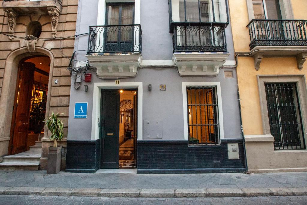 ein weißes Gebäude mit einer Tür und einem Balkon in der Unterkunft Ibarra Hostel in Sevilla
