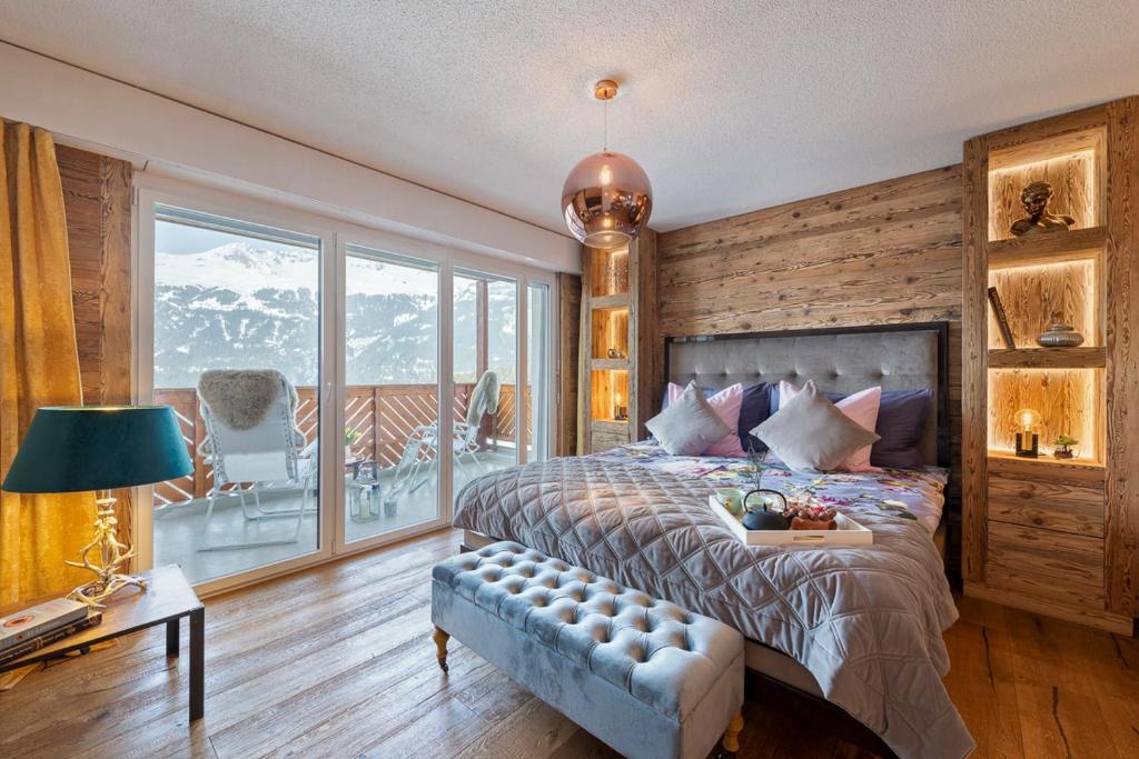 ein Schlafzimmer mit einem Bett und einem großen Fenster in der Unterkunft Apartment 42 Crans in Crans-Montana