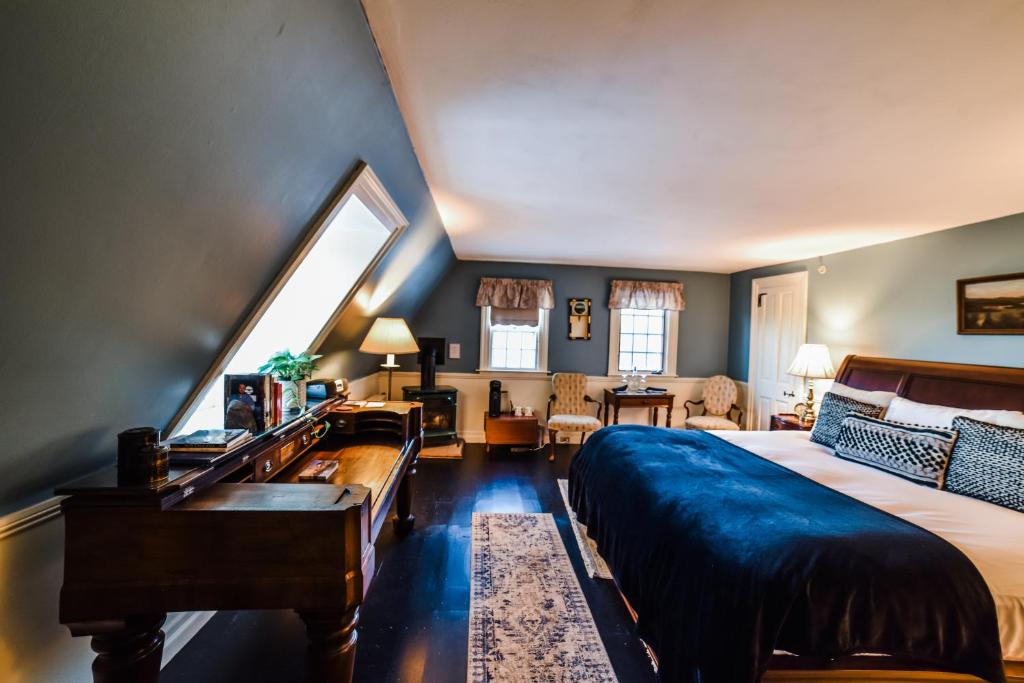 1 dormitorio con 1 cama grande y piano en Adair Country Inn & Restaurant, en Bethlehem