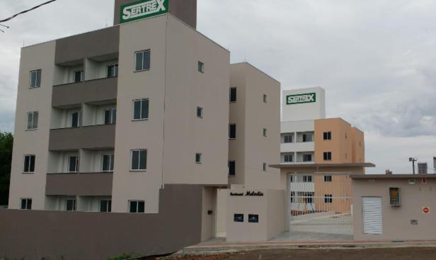 ein weißes Gebäude mit zwei Wohnungen im Hintergrund in der Unterkunft Residencial Melodia in Campos Novos