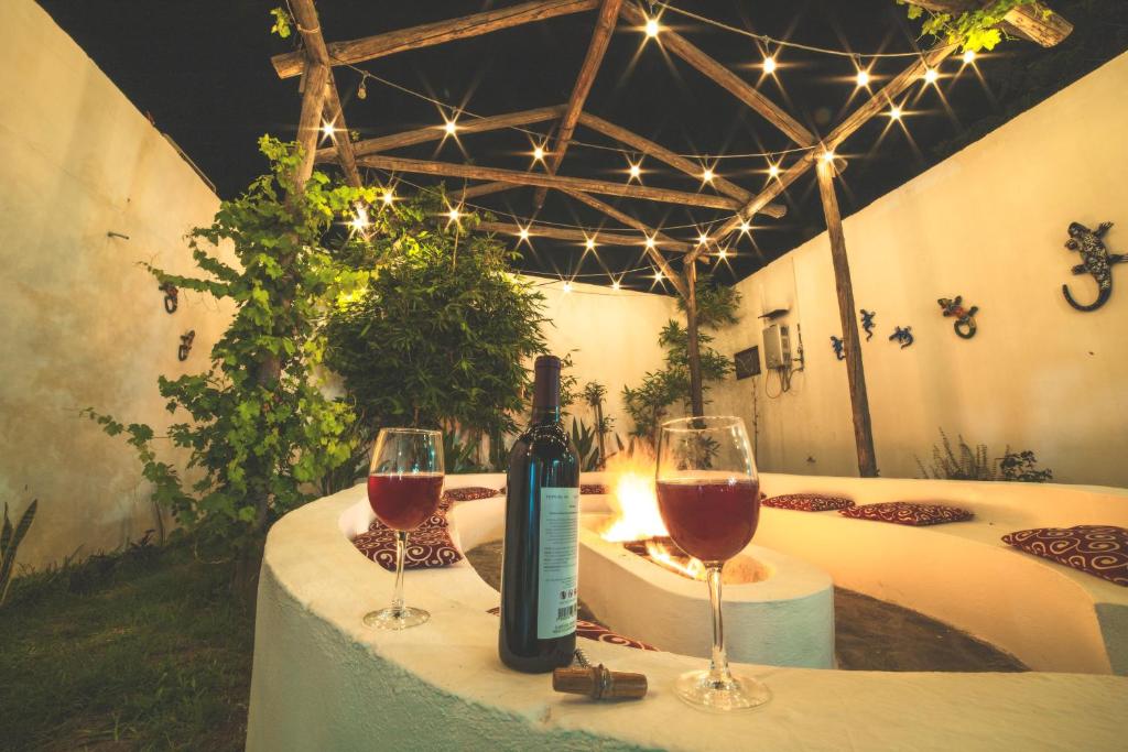 een tafel met twee wijnglazen en een fles wijn bij Hotel Posada las Nubes in Parras de la Fuente