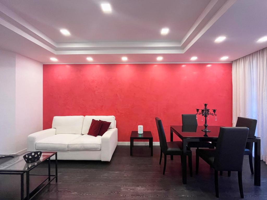 a living room with a white couch and a red wall at Elegante bilocale Torre Pontina in Latina