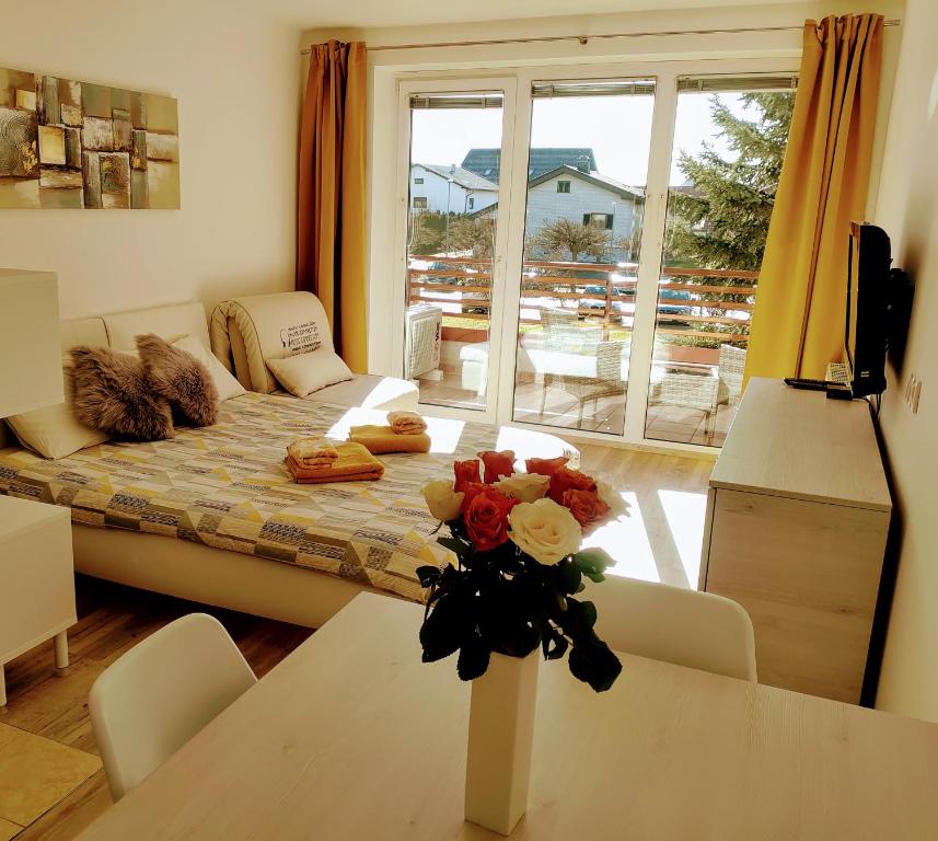 een woonkamer met een tafel met bloemen erop bij Apartma MAX in Moravske-Toplice