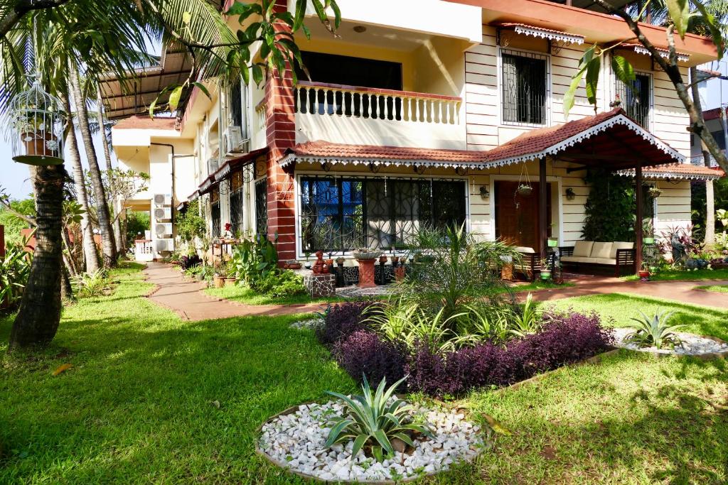 una casa con un jardín delante de ella en SHANU'S SEASIDE INN - A Guesthouse, 100 metres to Candolim Beach, en Candolim