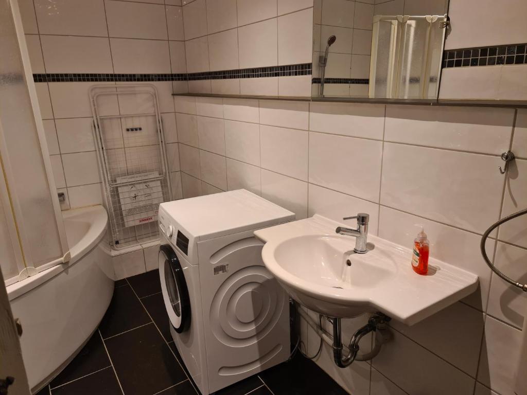 a bathroom with a sink and a washing machine at GSS18 1-OG Möblierte Wohnung in Oebisfelde in Oebisfelde