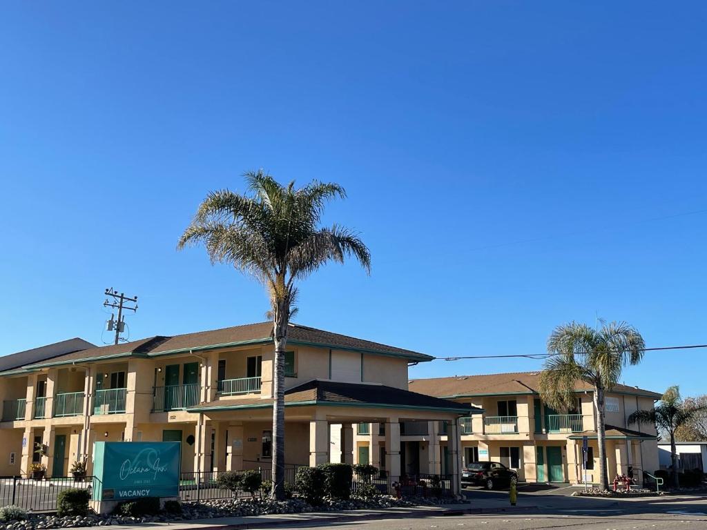 a building with a palm tree in front of it at Oceano Inn in Oceano