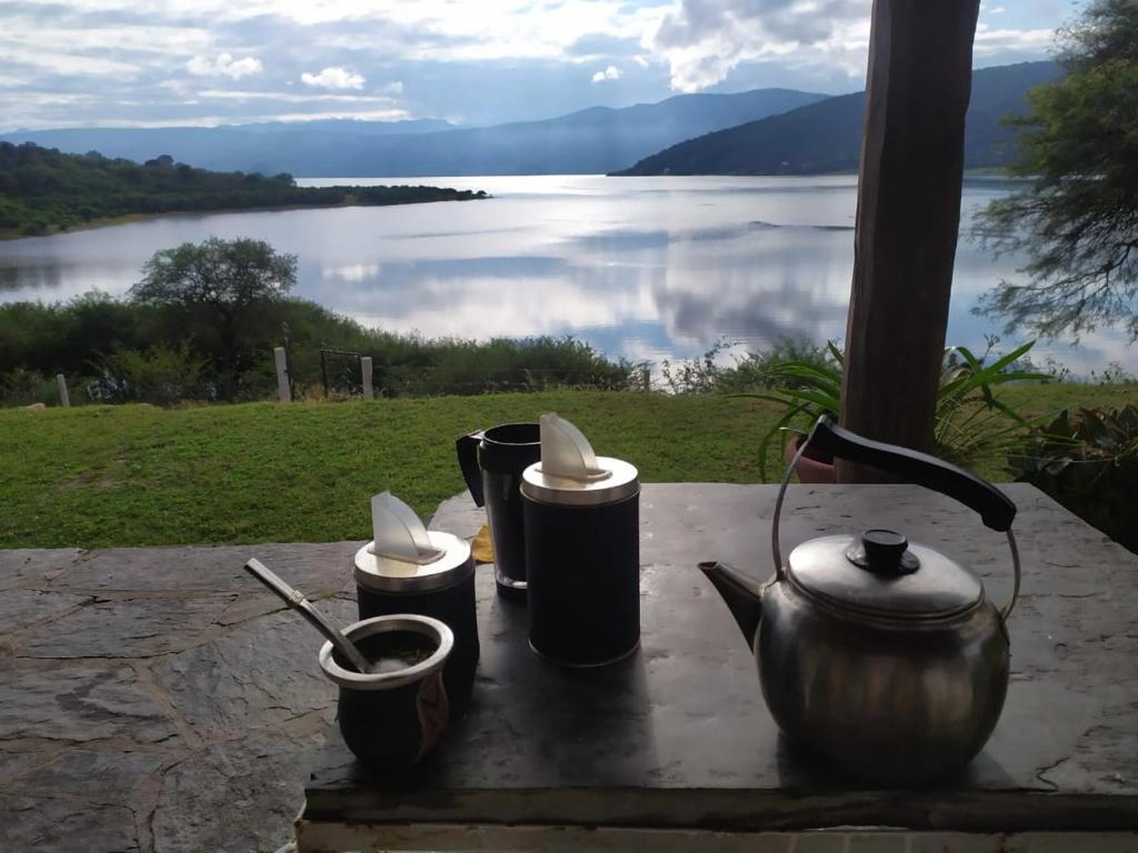 a table with pots and pans and a view of a lake at TIKI HUASI in Coronel Moldes