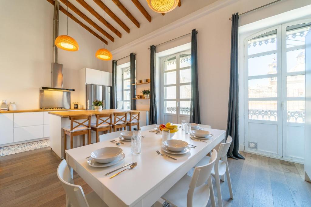 cocina y comedor con mesa blanca y sillas en LovelyLofts Altamira Duplex, en Alicante
