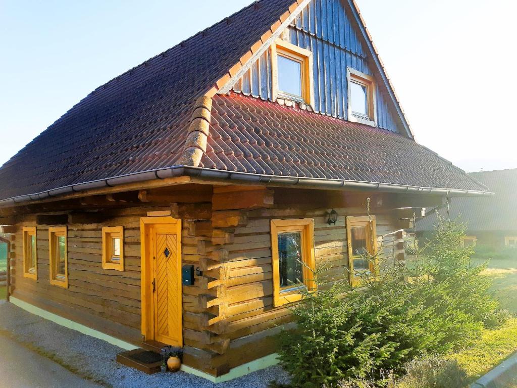 a small log cabin with a gambrel roof at Chata Raj in Hrabušice