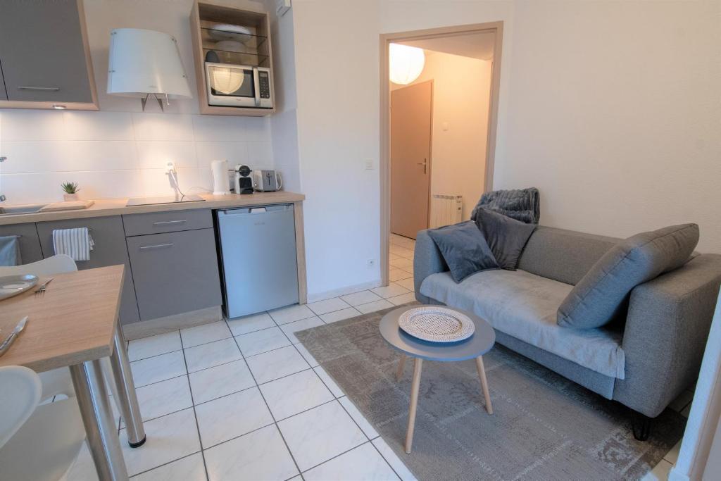 ein Wohnzimmer mit einem Sofa und einem Tisch in der Unterkunft CABANA &amp; Voie Verte - Parking, Terrasse, Lac in Saint-Jorioz