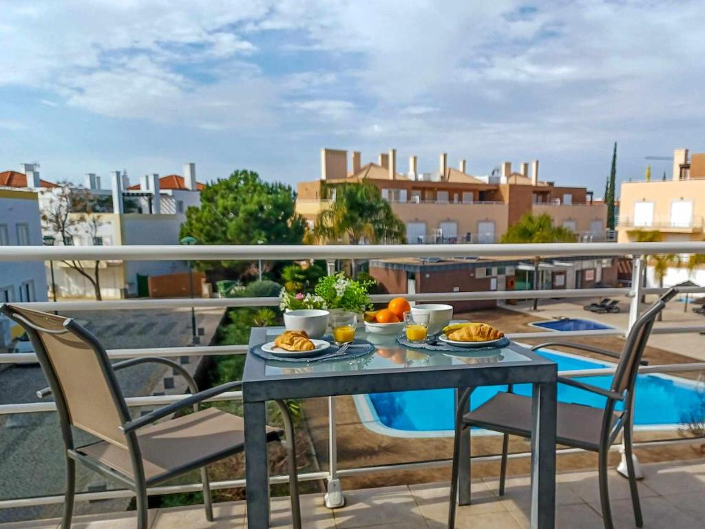un tavolo con piatti di cibo in cima a un balcone di Apartamento AzulMar Cabanas Gardens by Your Home Algarve a Armação da Abóbora