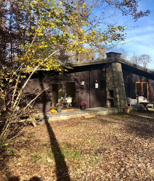 a black house with a yard in front of it at Forest Lodge in Petit Mesnil