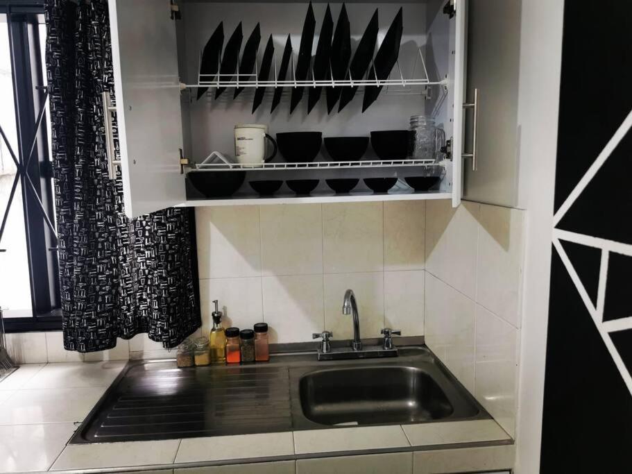 a kitchen with a sink and a shelf with pots and pans at Hermoso apartamento en el centro histórico de San Gil I 2 in San Gil