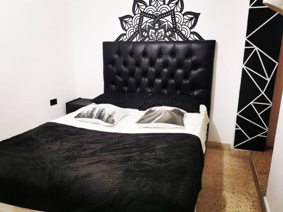 a black bed with a black headboard in a bedroom at Hermoso apartamento en el centro histórico de San Gil I 2 in San Gil