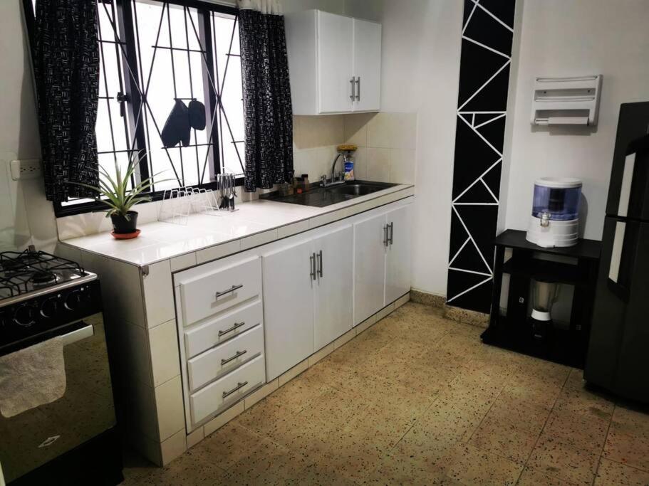 a kitchen with white cabinets and a sink and a window at Hermoso apartamento en el centro histórico de San Gil I 2 in San Gil