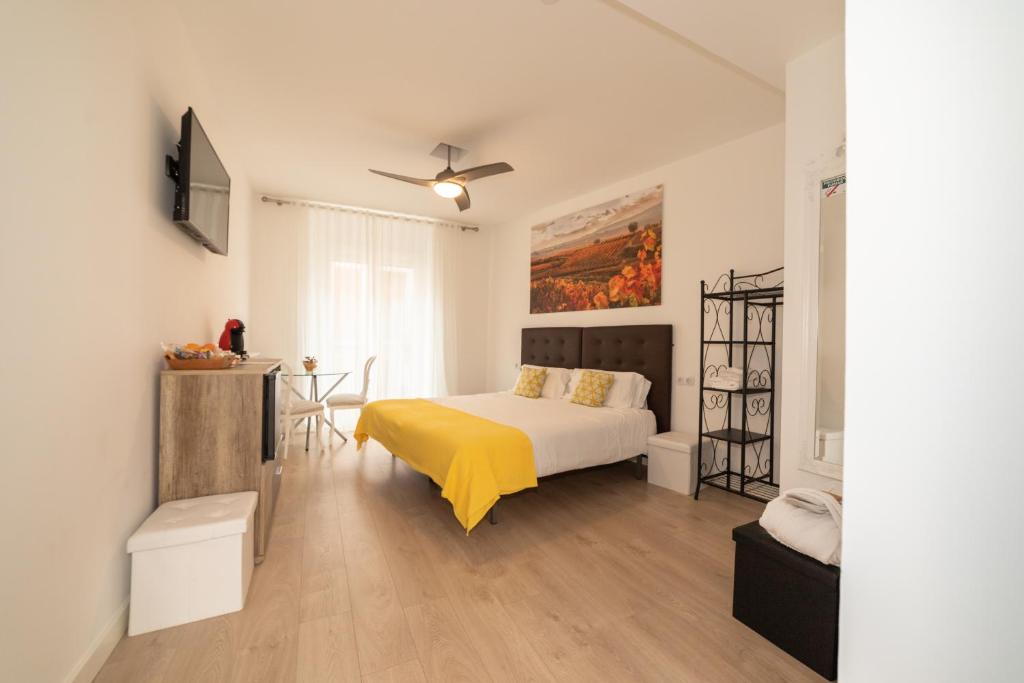 um quarto com uma cama com um cobertor amarelo em Hostal Puente de Hierro em Logroño