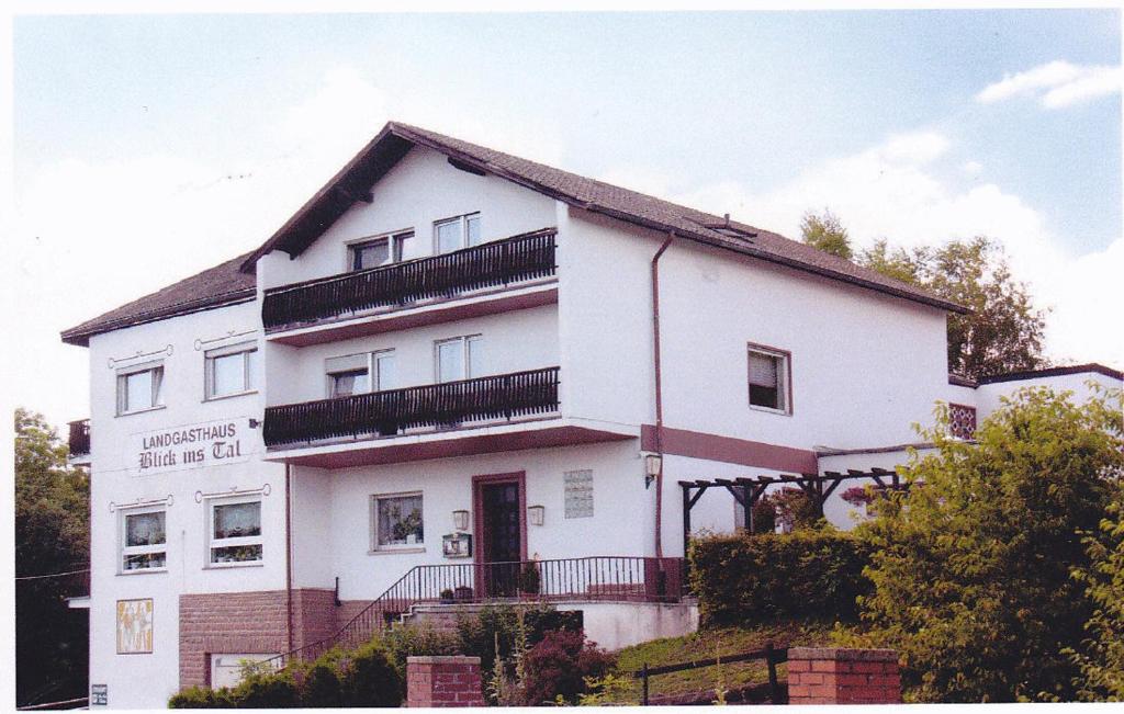 un edificio blanco con balcones encima en Landgasthaus Blick ins Tal, en Wißmannsdorf