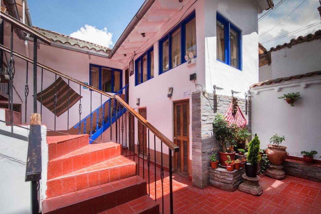 una casa con escaleras y plantas delante de ella en Hotel Guest House Wayra, en Cusco