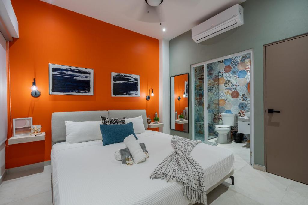 um quarto com uma parede em tons de laranja e uma cama em La Buena Vida Inn em San Juan