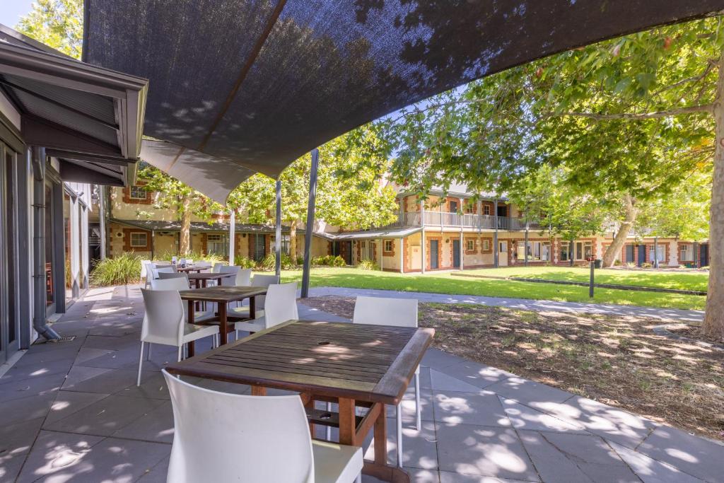 an outdoor patio with tables and white chairs at St Francis Winery in Old Reynella