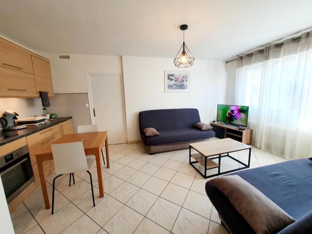 a living room with a couch and a table at Apart 5 personnes, 1min Gare d'Annemasse, Genève 5km in Annemasse