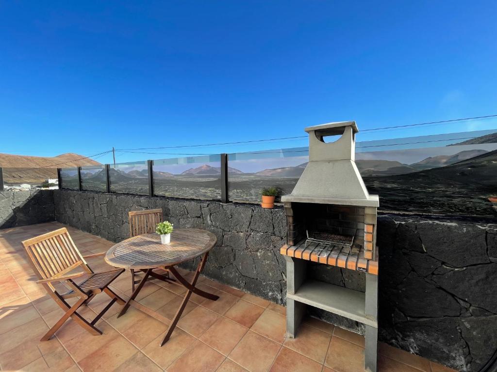a patio with a table and a wood stove at Eslanzarote Casa Carait, Super wifi, Sat tv in La Vegueta