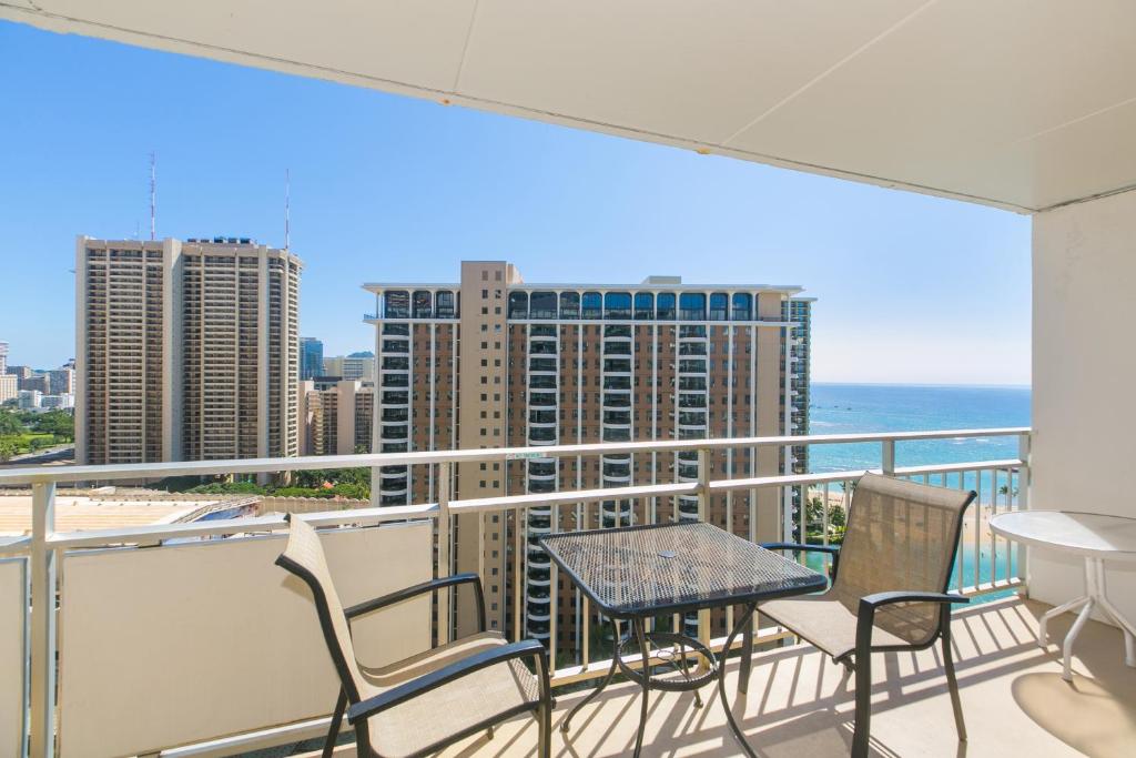 een balkon met een tafel en stoelen en de oceaan bij Ilikai Tower 1936 Lagoon View 1BR in Honolulu